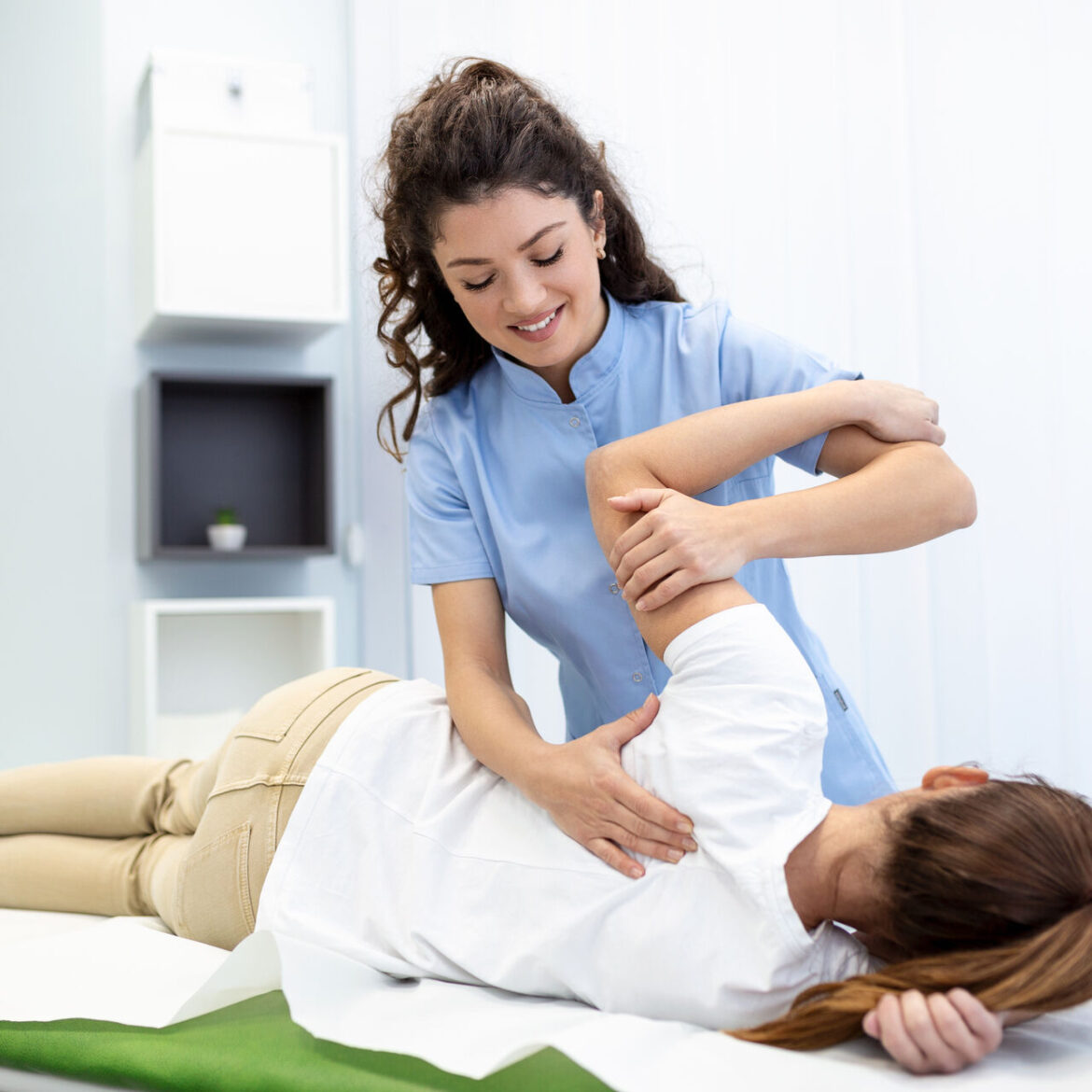 Physiotherapist treatment patient. Holding patient’s hand, shoulder joint treatment. Physical Doctor consulting with patient About Shoulder muscule pain problems Physical therapy diagnosing concept